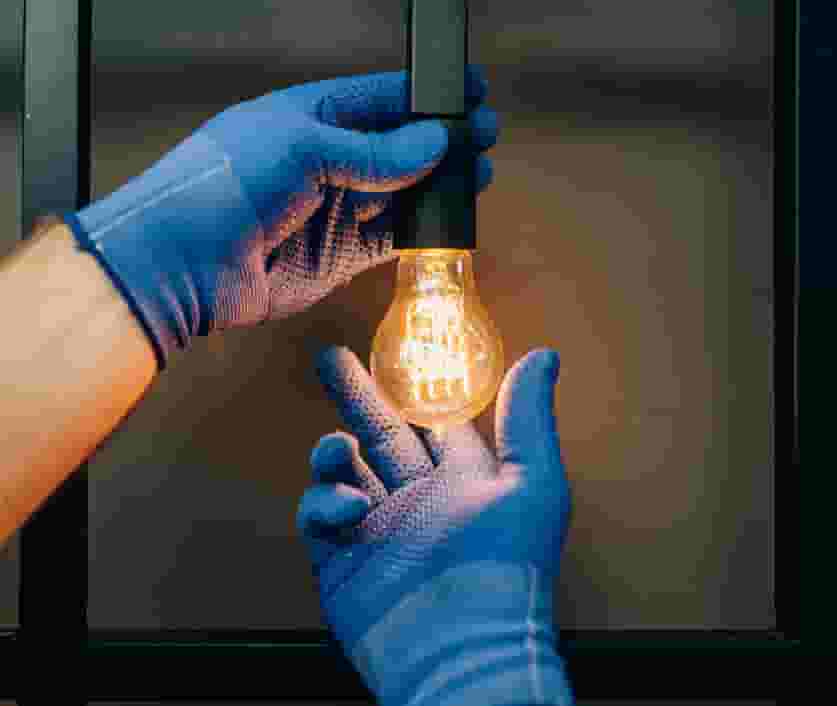 Maintenance professional changing light bulb