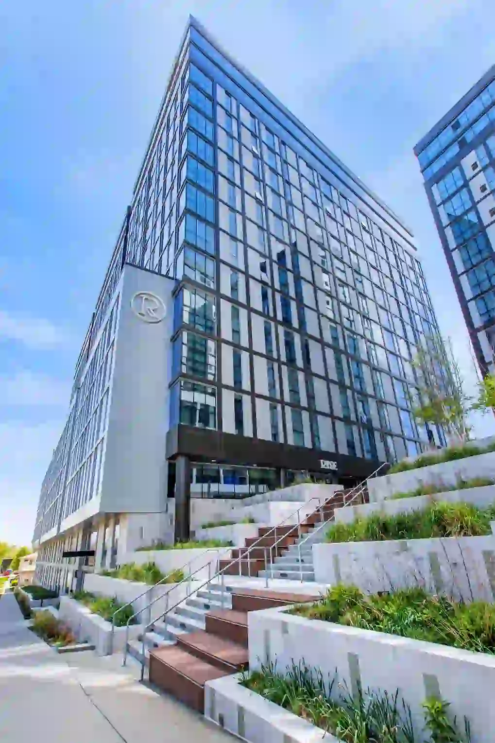 Exterior, full height view of Rise at Riverfront Crossings and landscaping